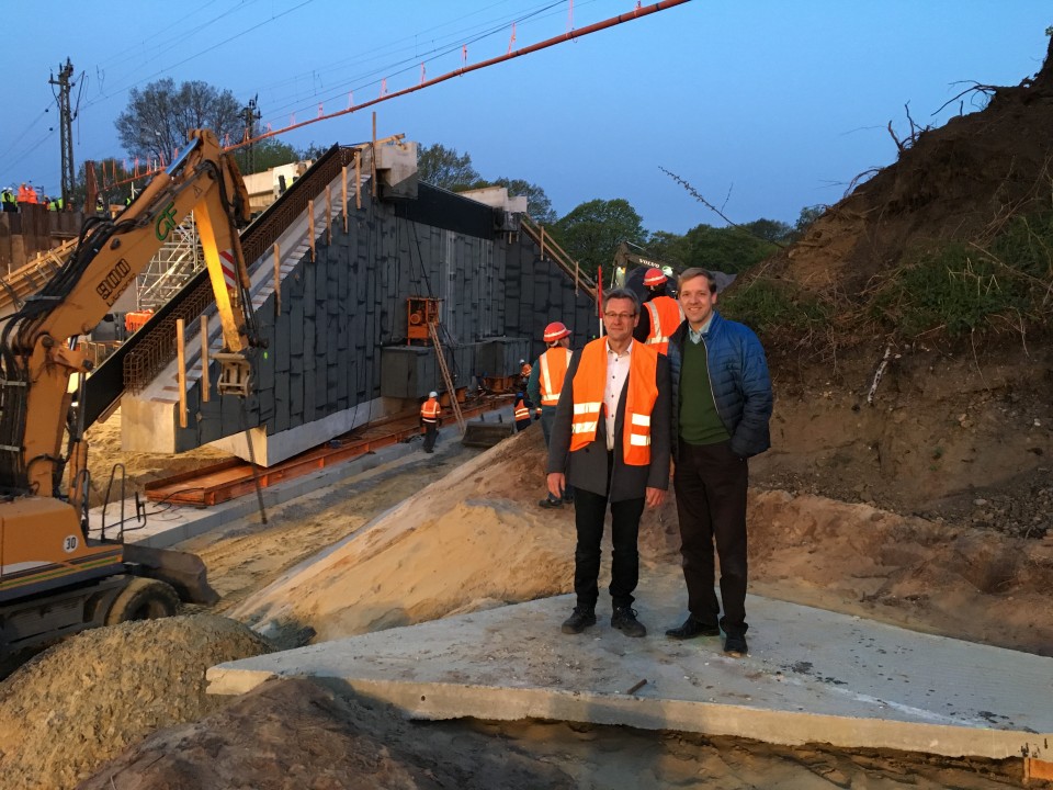 Landrat Dr. Christian Schulze Pellengahr (rechts) ließ sich durch Straßenbau-Abteilungsleiter Klaus Dammers über den Einschub des Brückenbauwerks informieren.